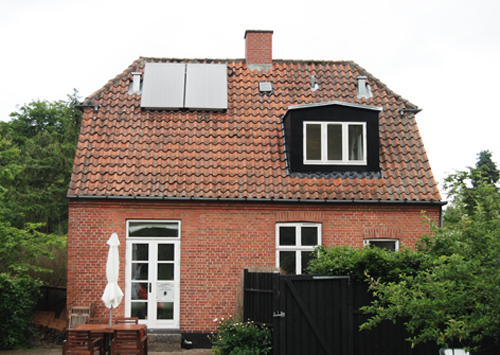 Huset set fra haven - efter solvarmepaneler og ventilationshætter